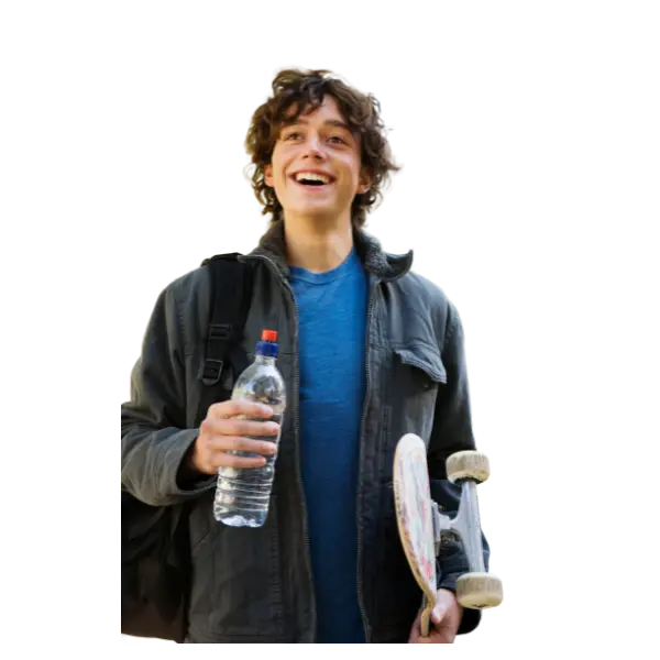 Teen student smiling and carrying a skateboard and his backpack.